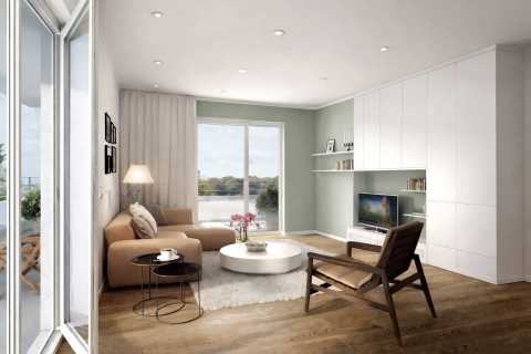 Modernes Wohnzimmer mit Sofa, Sessel, TV, Couchtisch und großem Fenster.