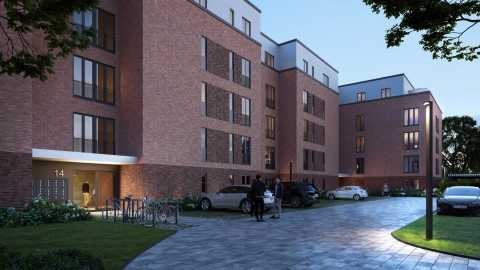 Moderne Wohnanlage mit roten Backsteinen, Autos, Fahrrädern und beleuchtetem Eingang.