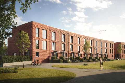 Reihenhaus aus rotem Klinker, davor Wiese und Gehweg mit Menschen.