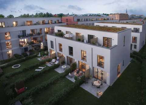 Moderne Wohnanlage mit begrünten Dächern, Balkonen und gepflegten Gärten.