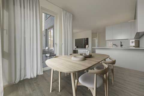 Helle, moderne Küche mit Esstisch, Holzstühlen und Zugang zu Terrasse.