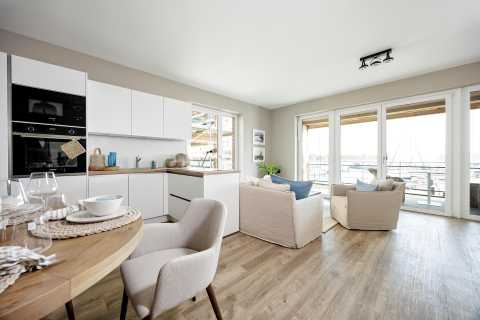 Helle, moderne Wohnküche mit Essbereich, Sitzecke und Blick auf den Hafen